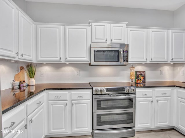 kitchen with appliances with stainless steel finishes and white cabinets