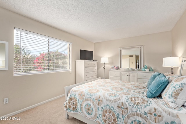 bedroom with light colored carpet and a textured ceiling