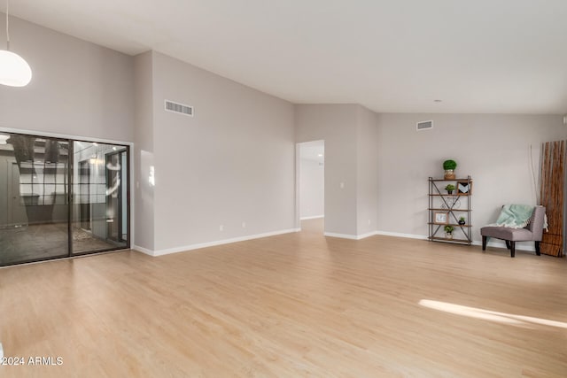 unfurnished living room featuring hardwood / wood-style floors and vaulted ceiling