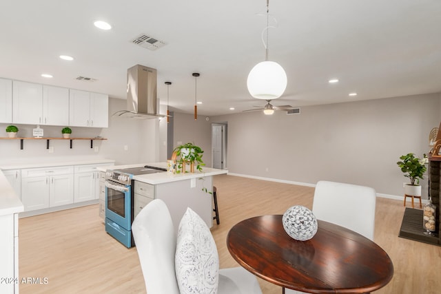 kitchen with exhaust hood, stainless steel electric stove, a center island, decorative light fixtures, and white cabinets