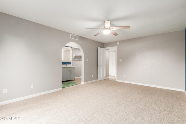 unfurnished bedroom featuring ceiling fan, carpet flooring, and ensuite bath