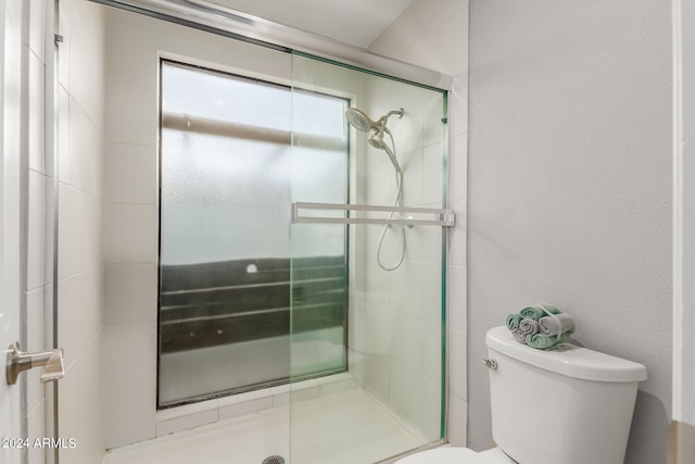 bathroom with toilet and an enclosed shower