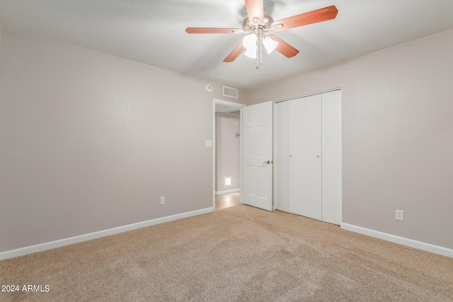 unfurnished bedroom with a closet, ceiling fan, and light carpet