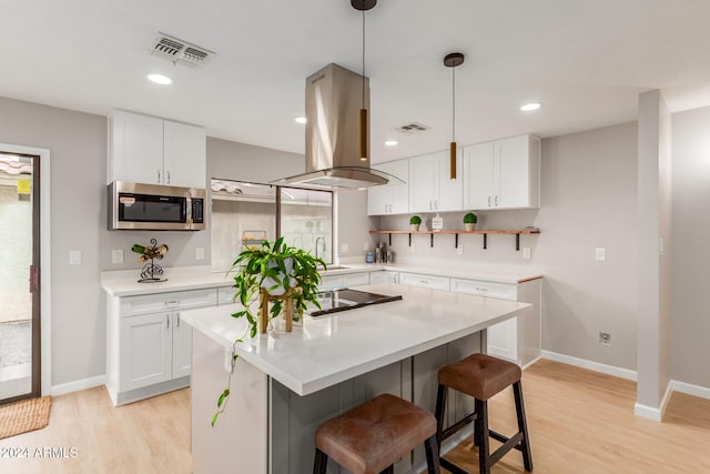 2114 S El Marino, Mesa, AZ 85202 - kitchen with stainless steel microwave, island exhaust hood, white cabinetry, visible vents, and a sink