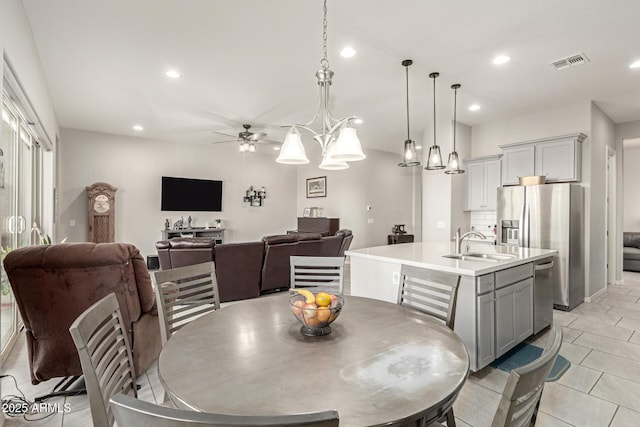 dining area with light tile patterned flooring, sink, and ceiling fan