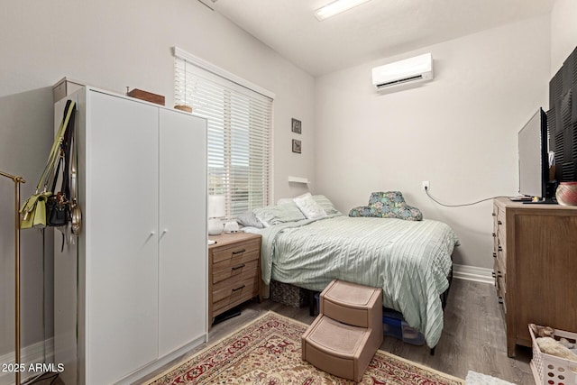 bedroom featuring light hardwood / wood-style floors and an AC wall unit