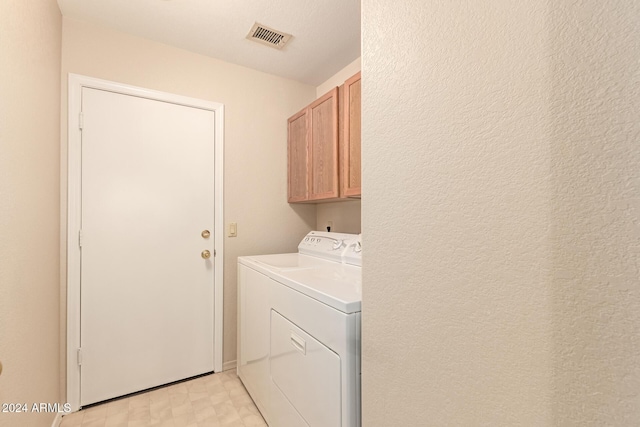 washroom featuring washer and dryer and cabinets