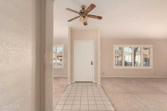 carpeted entrance foyer with a wealth of natural light and ceiling fan