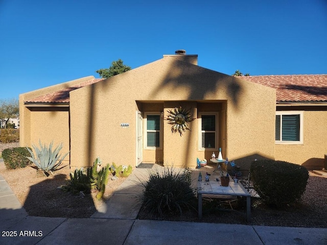 pueblo revival-style home with a patio area