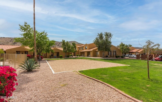 view of community featuring volleyball court and a lawn