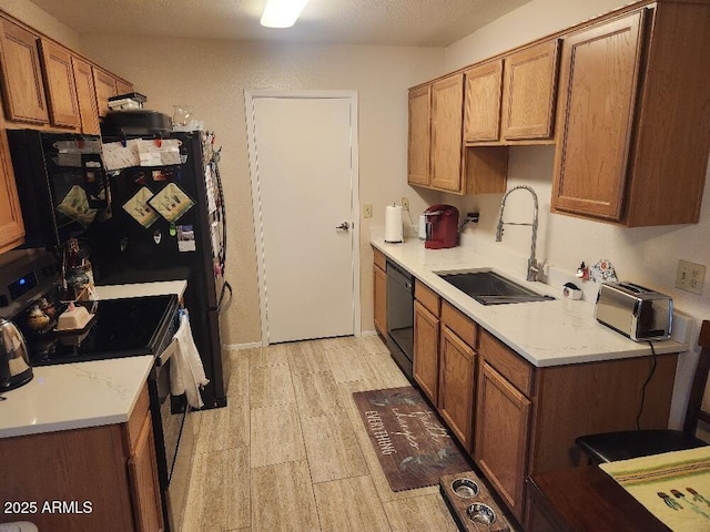 kitchen with sink, black appliances, and light hardwood / wood-style flooring