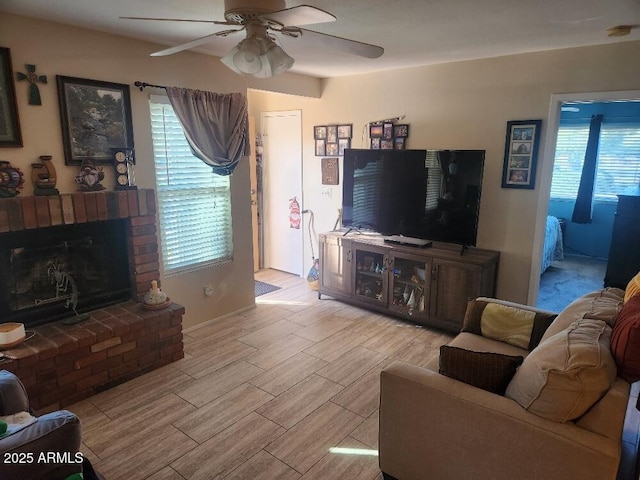 living room featuring ceiling fan, a brick fireplace, and a healthy amount of sunlight