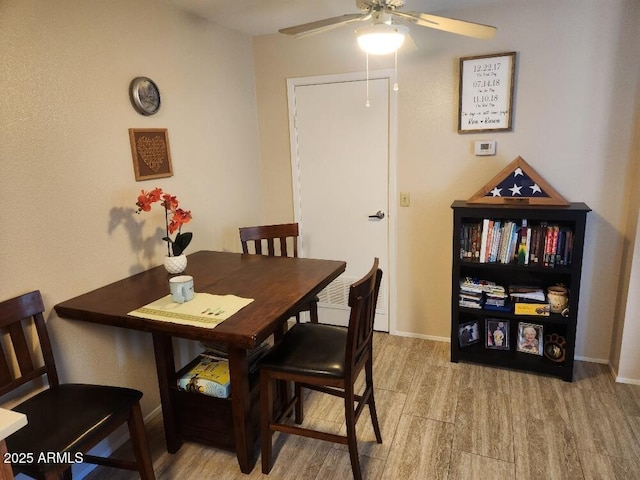 dining space with light hardwood / wood-style flooring and ceiling fan