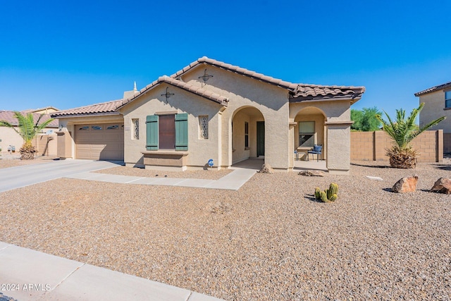 mediterranean / spanish-style house with driveway, an attached garage, a tile roof, and stucco siding