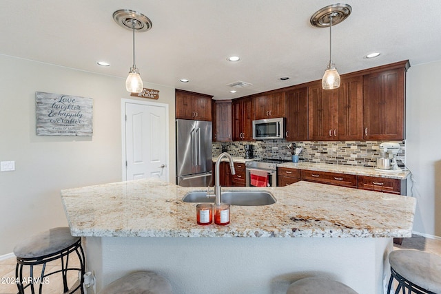 kitchen with high end appliances, decorative light fixtures, sink, and backsplash