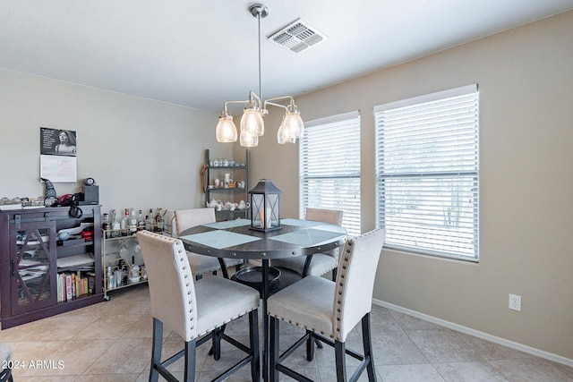 tiled dining space featuring an inviting chandelier