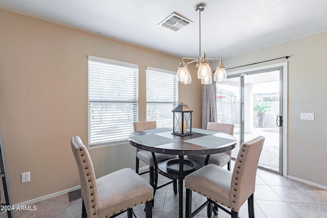 dining space with a healthy amount of sunlight, a chandelier, and light tile patterned floors