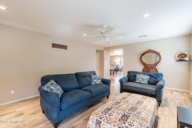 living room featuring ceiling fan and light hardwood / wood-style flooring