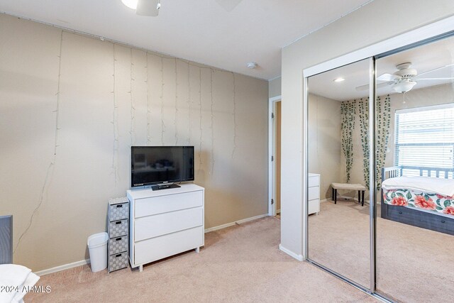 carpeted bedroom with a closet and ceiling fan