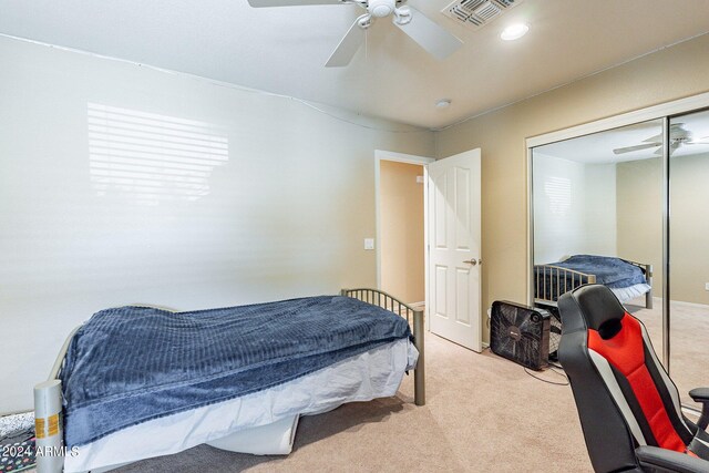 bedroom featuring ceiling fan, light colored carpet, and a closet