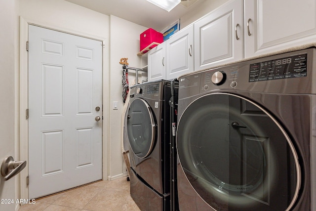 laundry area featuring light tile patterned flooring, separate washer and dryer, and cabinets