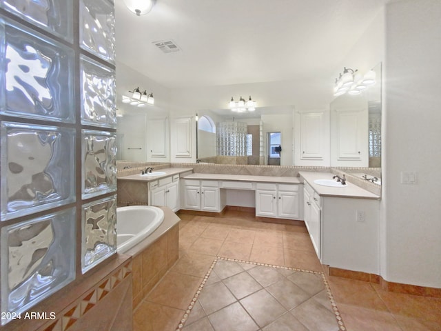 bathroom with tiled tub, tile floors, dual sinks, and large vanity