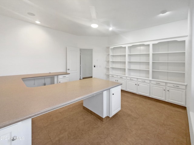 interior space featuring white cabinetry, light tile flooring, and kitchen peninsula