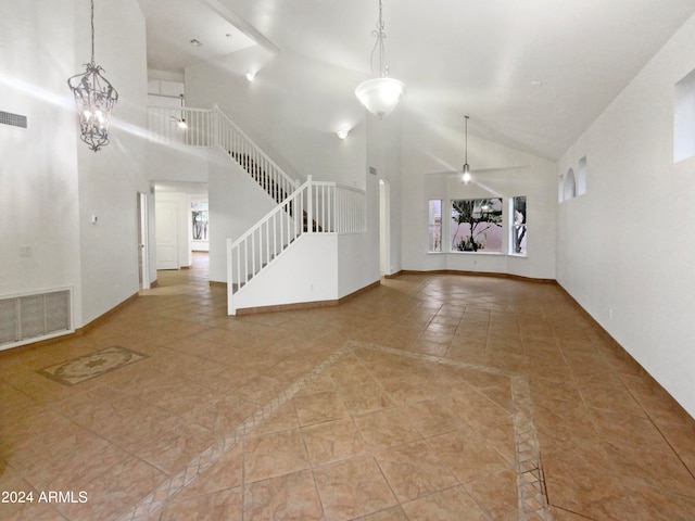 unfurnished living room featuring high vaulted ceiling, ceiling fan with notable chandelier, and light tile flooring