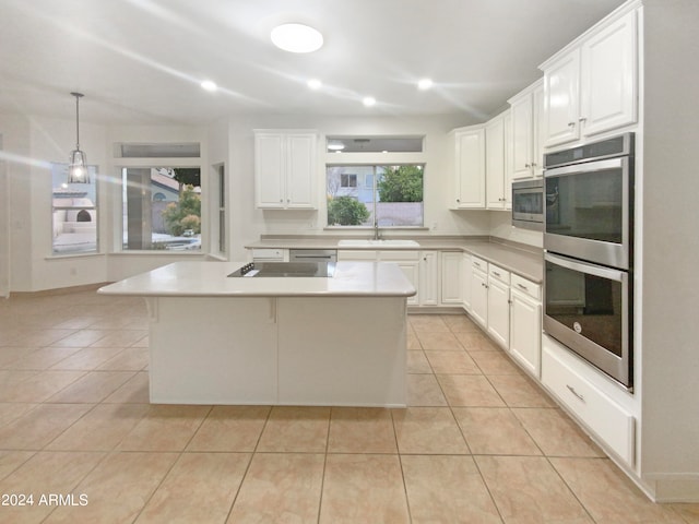 kitchen with white cabinets, hanging light fixtures, light tile flooring, and stainless steel appliances