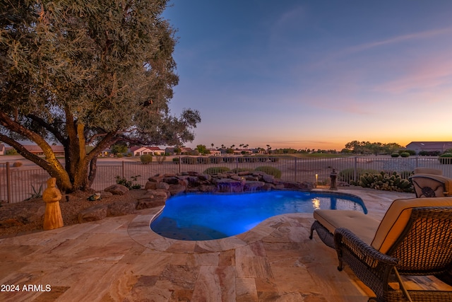 pool at dusk with a patio