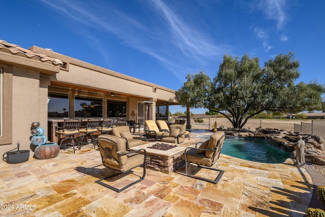 view of patio / terrace with a fenced in pool, pool water feature, and a fire pit