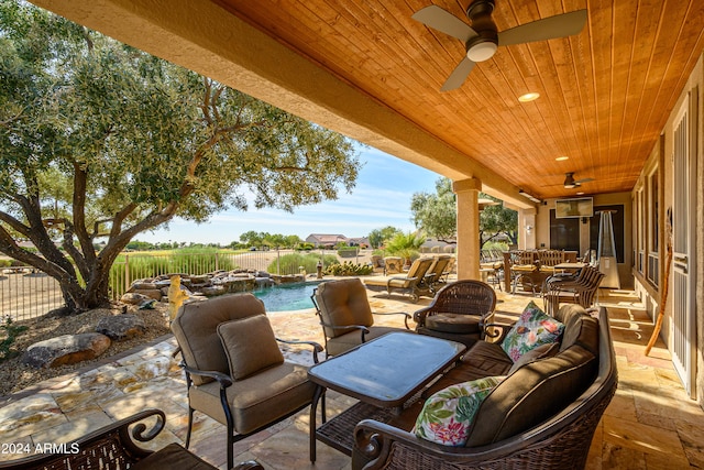 view of patio with an outdoor living space, a fenced in pool, and ceiling fan