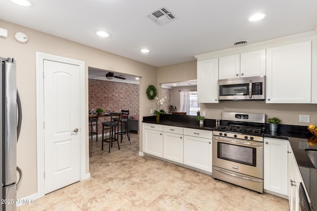 8155 E Columbus Ave, Scottsdale, AZ 85251 - kitchen with appliances with stainless steel finishes, dark countertops, white cabinets, recessed lighting, and wallpapered walls
