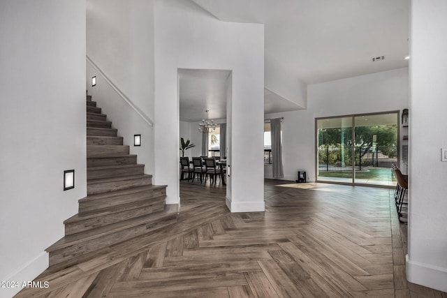 entrance foyer with dark parquet flooring, plenty of natural light, and a high ceiling