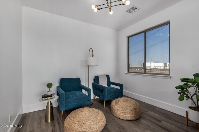 living area featuring dark wood-type flooring and a chandelier