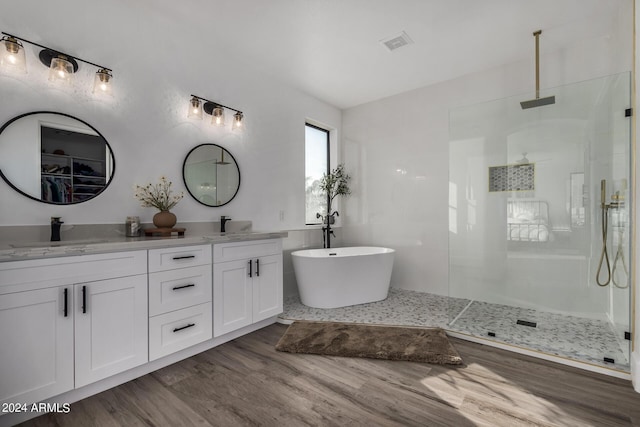 bathroom with vanity, wood-type flooring, plus walk in shower, and tile walls