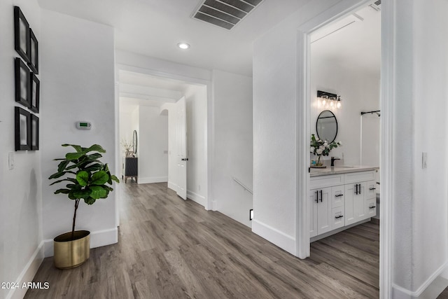 corridor with sink and light hardwood / wood-style floors