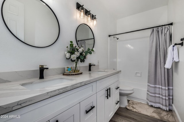 full bathroom with hardwood / wood-style flooring, vanity, shower / tub combo, and toilet