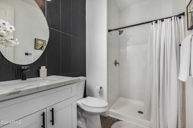 bathroom featuring walk in shower, vanity, toilet, and wood-type flooring