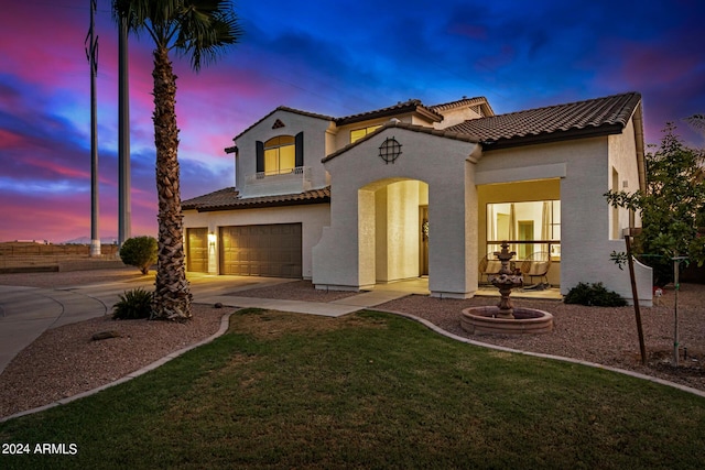 mediterranean / spanish house with a garage and a lawn