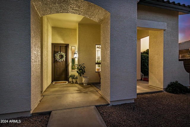 exterior entry at dusk with a patio area