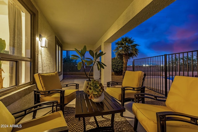 patio terrace at dusk featuring a balcony