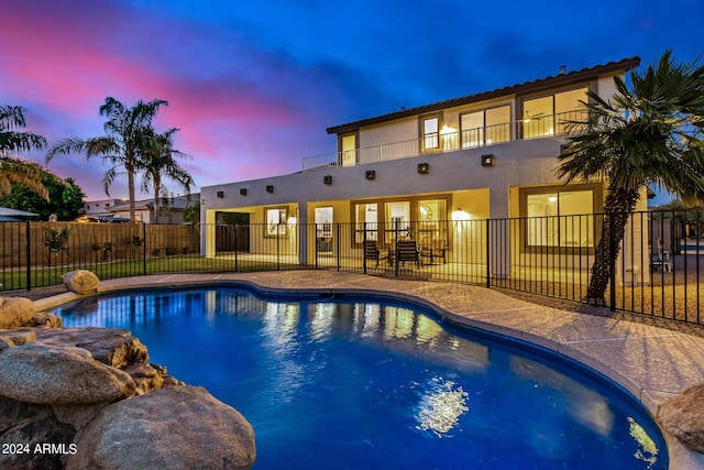 pool at dusk with a patio