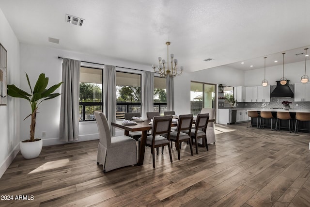 dining space with dark wood-type flooring, an inviting chandelier, and a textured ceiling