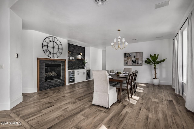 dining space featuring wine cooler, a notable chandelier, and wood-type flooring