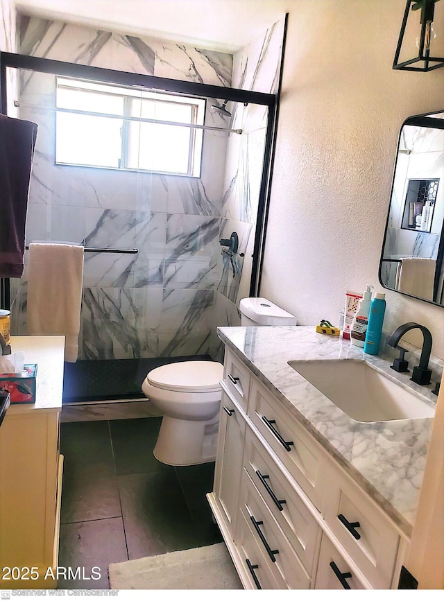 bathroom with vanity, tile patterned flooring, toilet, and walk in shower