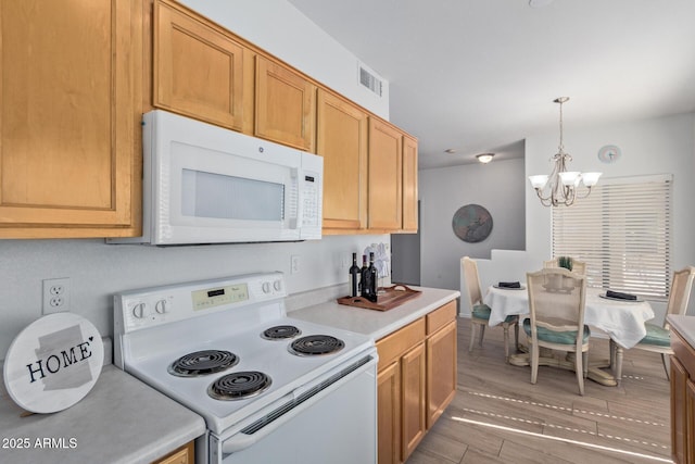 kitchen featuring hanging light fixtures, a notable chandelier, white appliances, light countertops, and visible vents