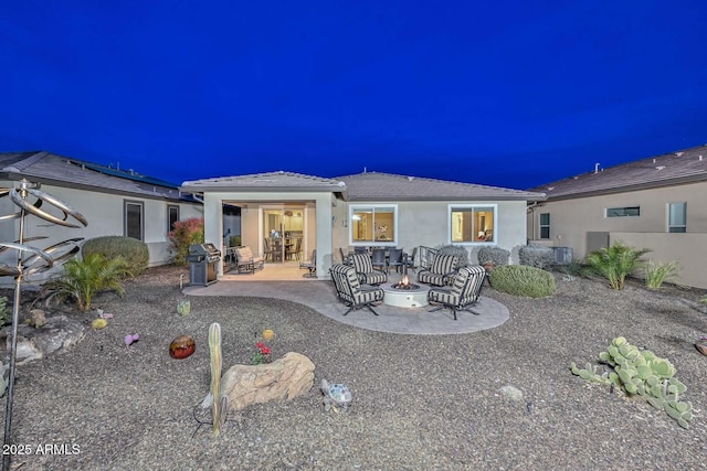 rear view of house featuring cooling unit, a patio area, and an outdoor fire pit