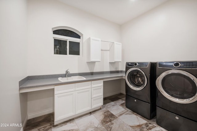 washroom with cabinets, sink, and washer and clothes dryer