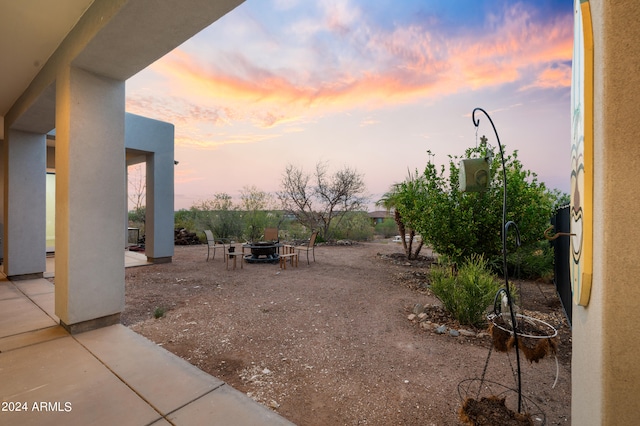 yard at dusk featuring a patio